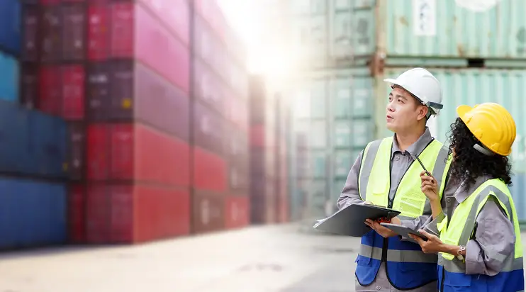two people evaluating shipping containers